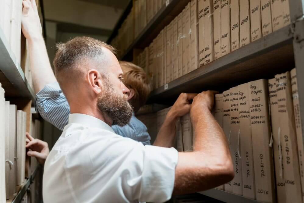 A man looking at the books in an archive
