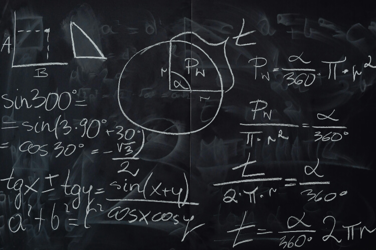 A chalkboard with white maths equations.