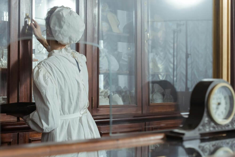 a curator cleaning a glass cabinet