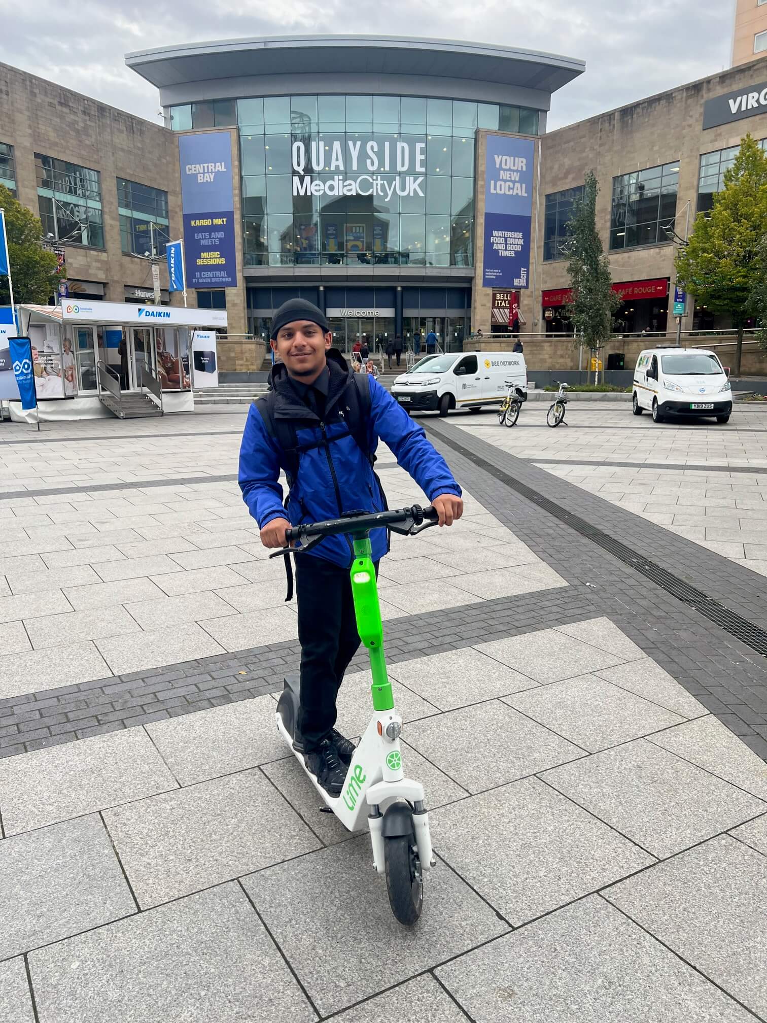 A student on an e-scooter outside Quayside MediaCity.