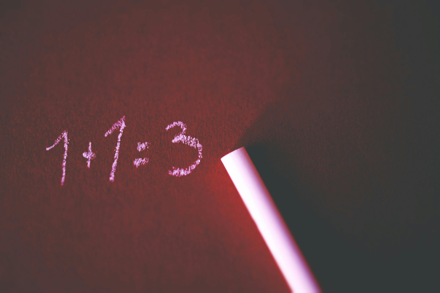 a 1+1=3 written on a board with pink chalk