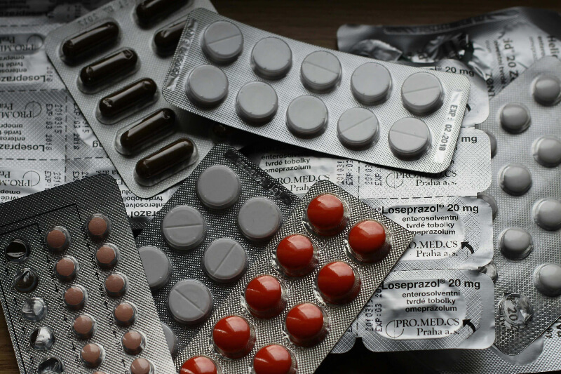 packets scattered about containing red and white tablets