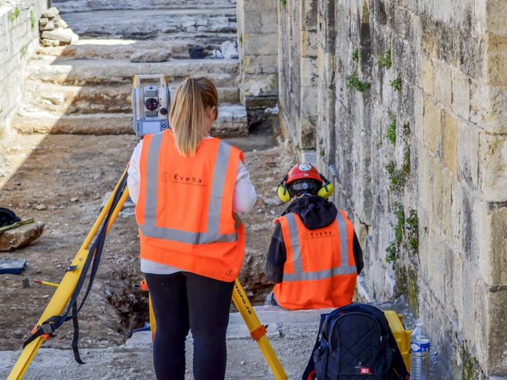 2 people working on an archaeological dig site 