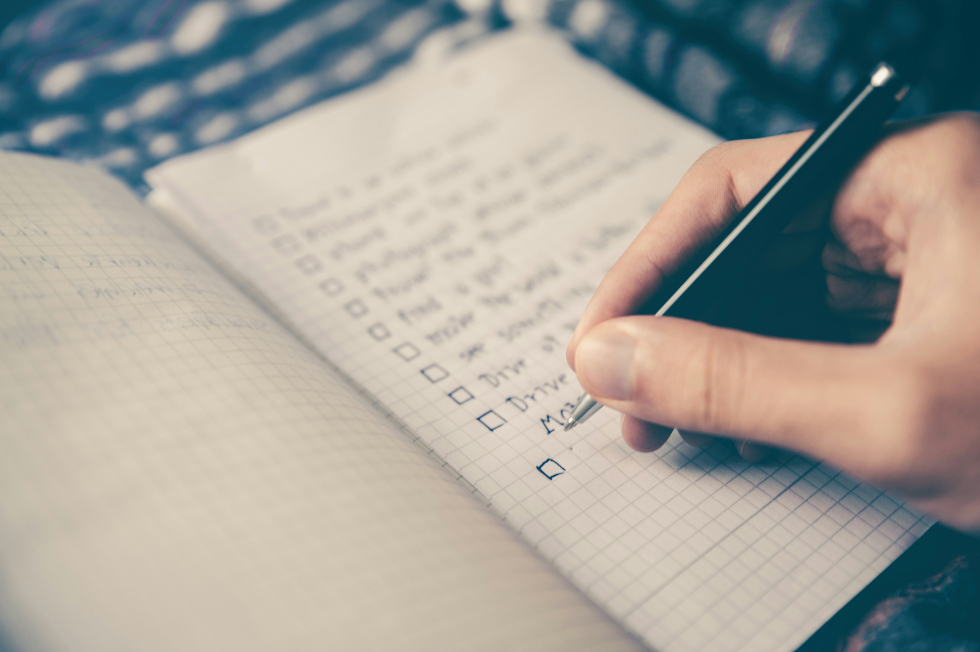 a person's hand on a piece of paper checking a box