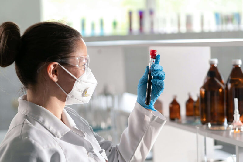 Female chemist analysing a sample of blood in a test tube