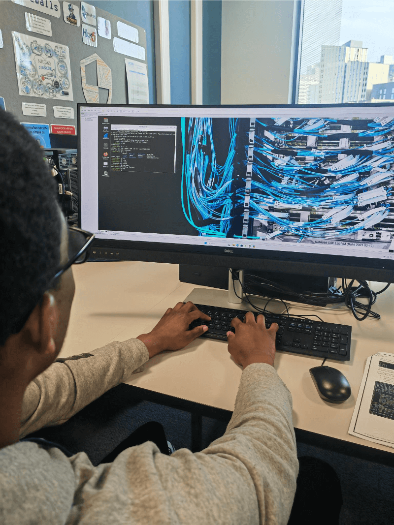 A young person at UCEN's training facility types on a keyboard.